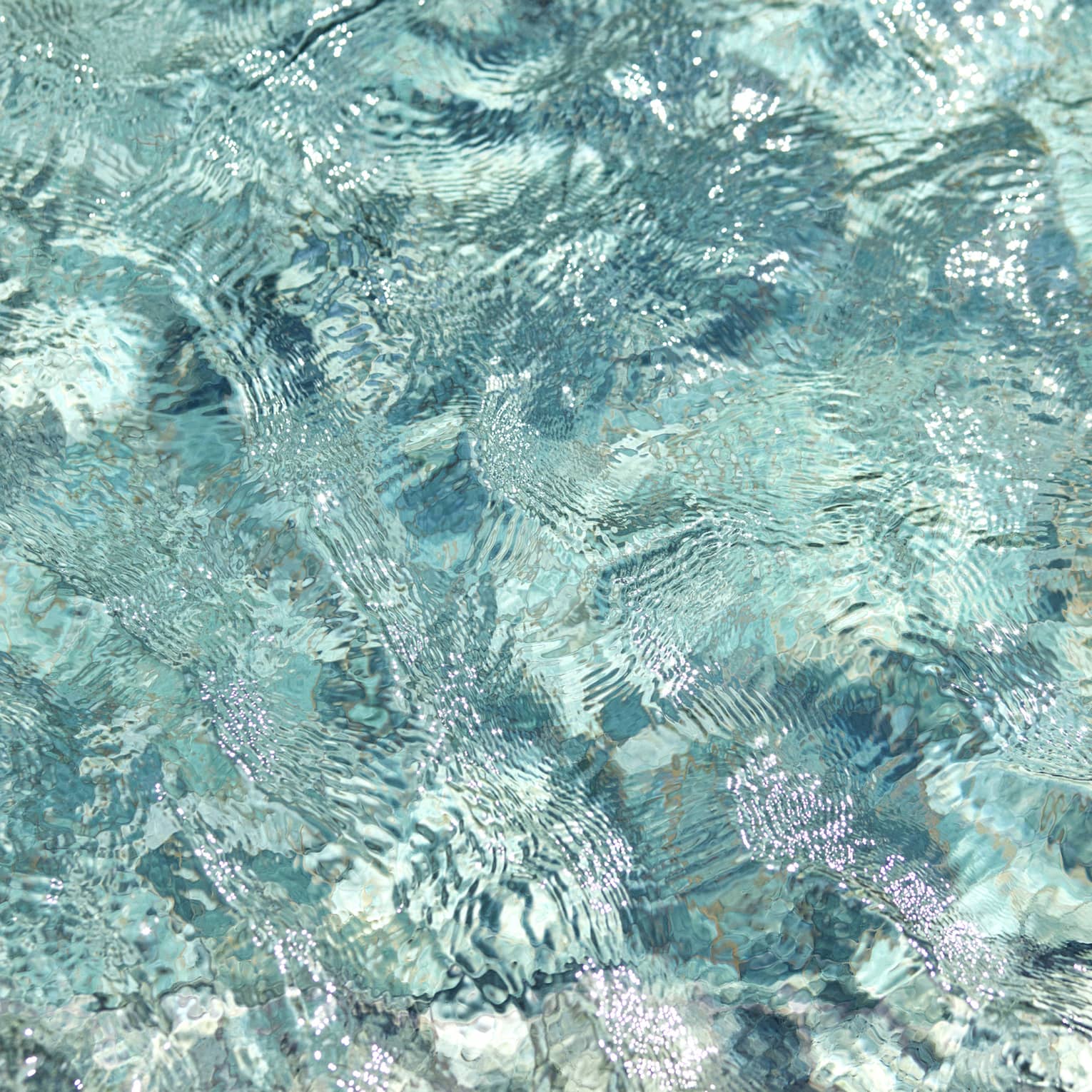 Ripples and wavelets on the surface of turquoise blue water.