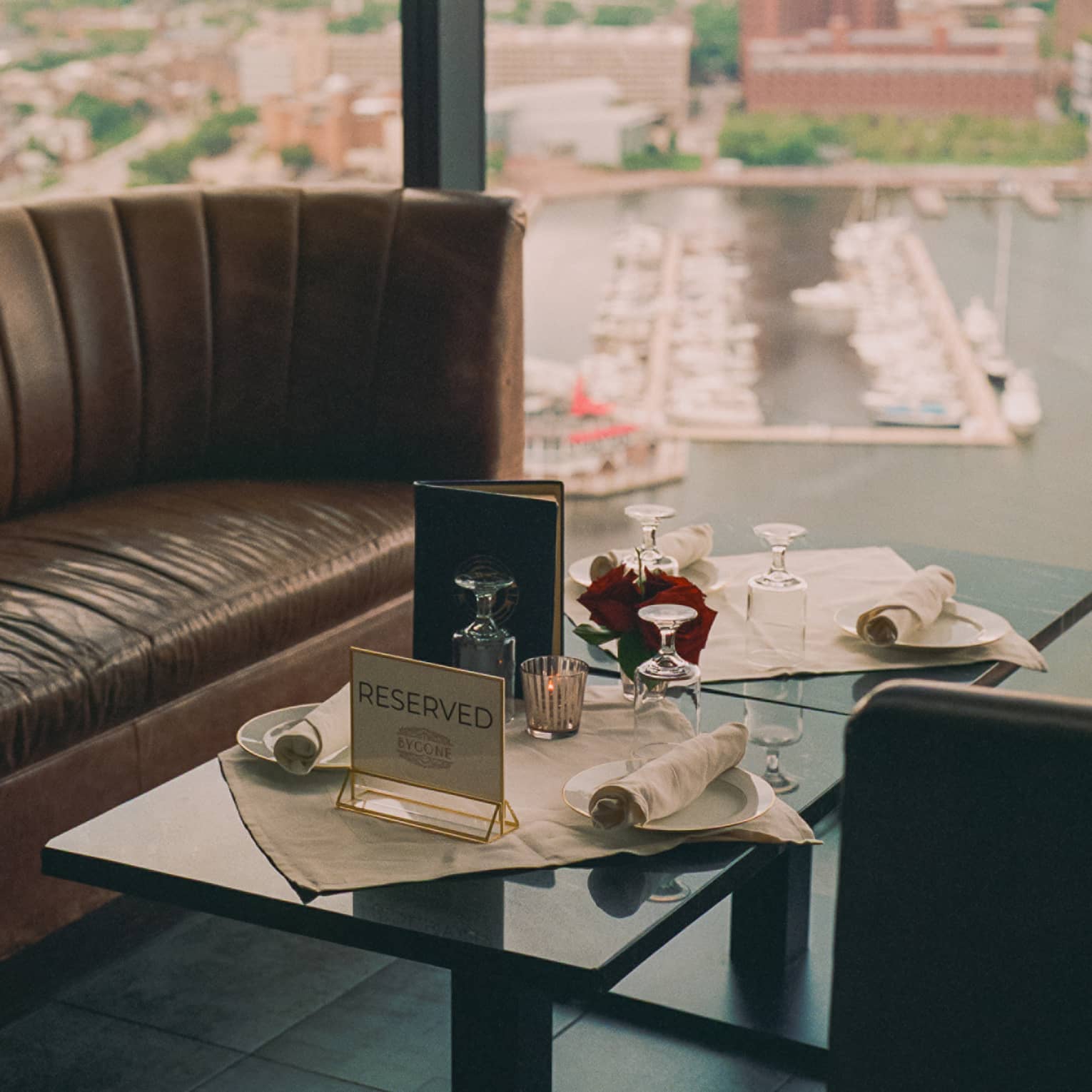 A small table and sofa near a large window.