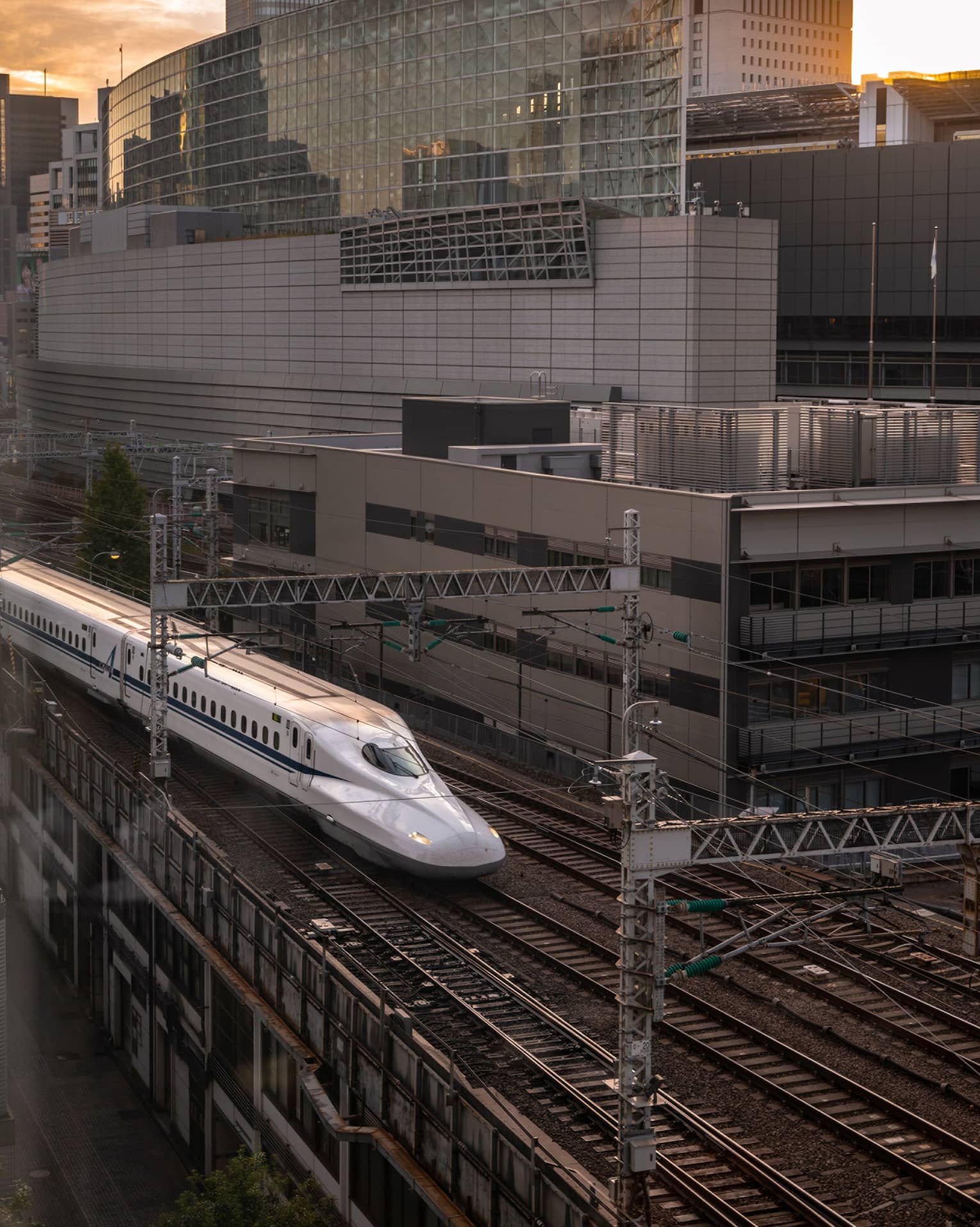 Shinkansen bullet train arrives at the station at sunset
