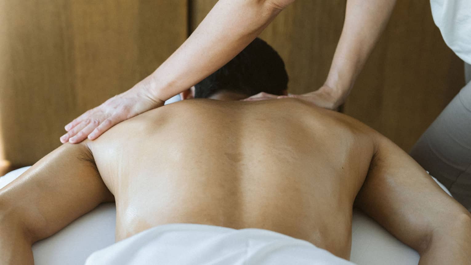 Man laying on massage table while getting a massage.