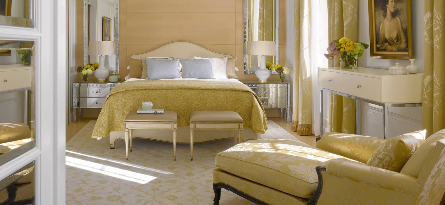 Presidential suite with queen bed, chaise lounge, and gold Victorian accents