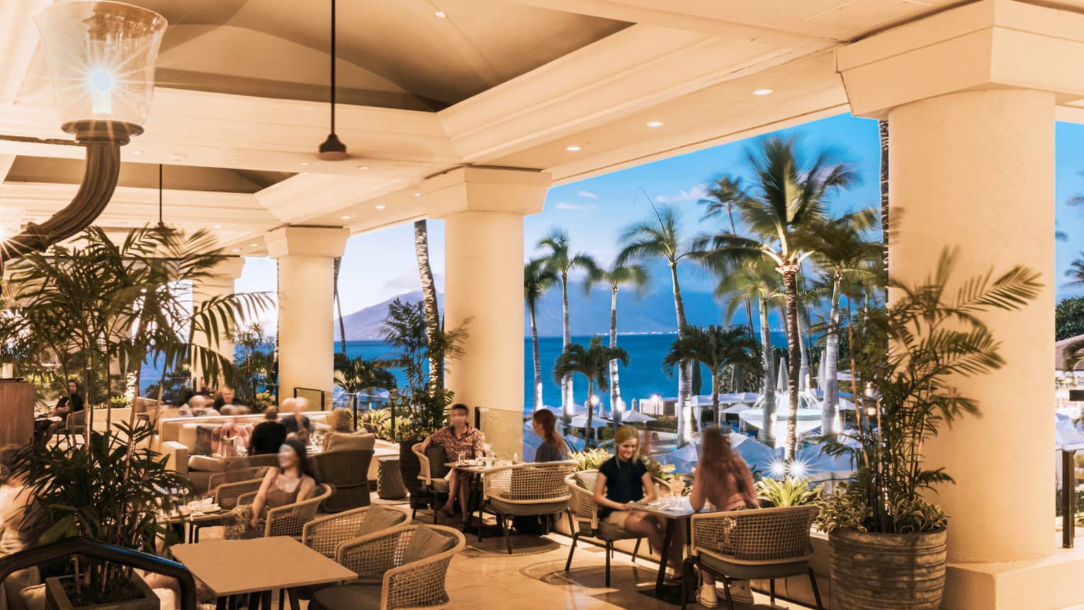 Open-air Lobby Lounge at sunset, palm trees, volcano in background