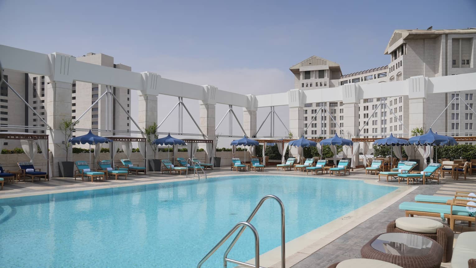 Rooftop pool surrounded by blue lounge chairs
