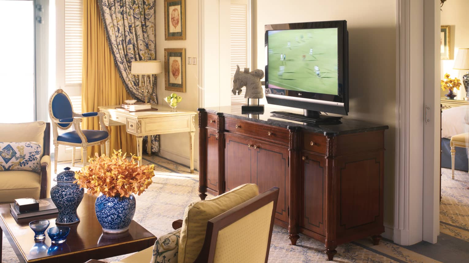 Sea-View One Bedroom Suite table with blue-and-white vases, cherry-wood dresser, flat-screen TV
