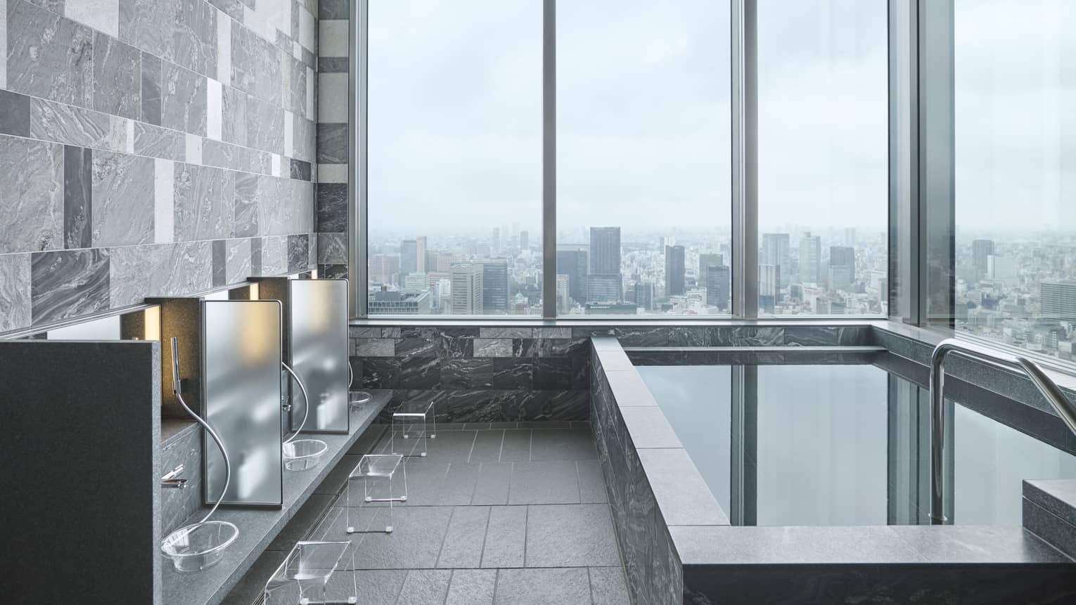 Japanese Ofuro corner bath with floor-to-ceiling windows overlooking the city