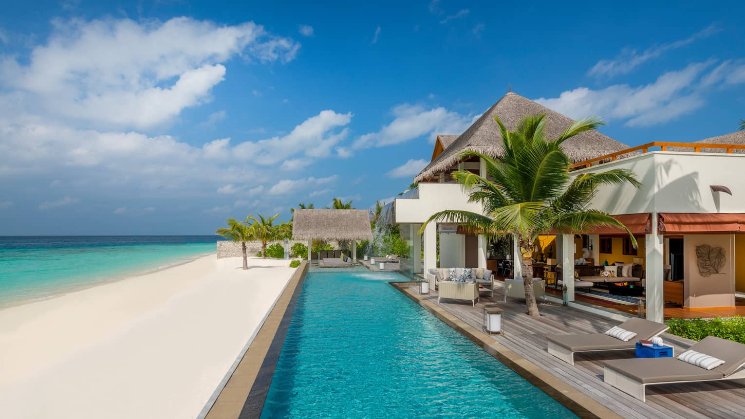 Three-Bedroom Landaa Estate villa deck by long swimming pool, white sand beach and ocean