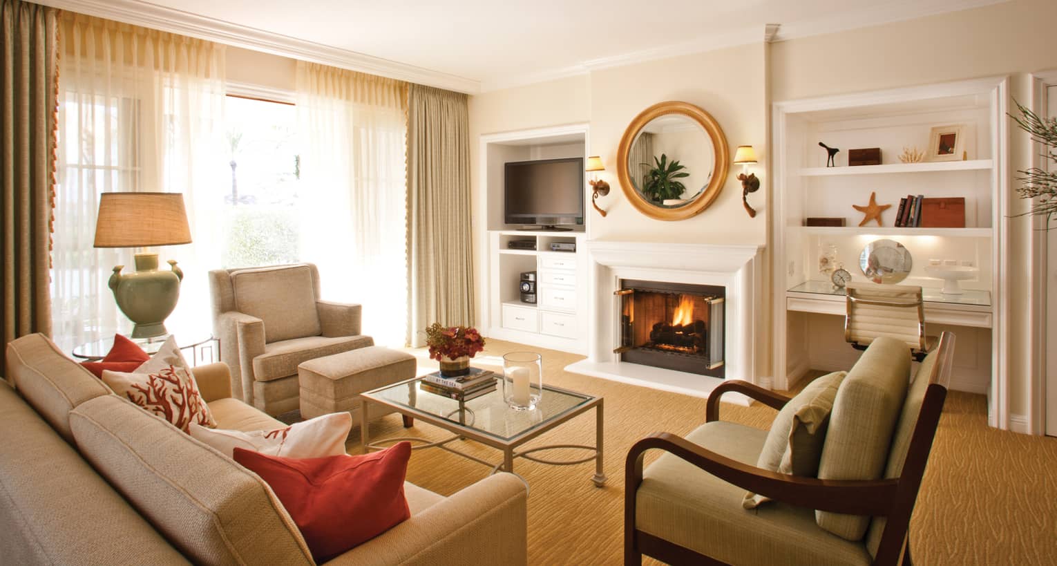 Two-bedroom resort residence living room sofa and armchairs by fireplace with white mantle, mirror, desk