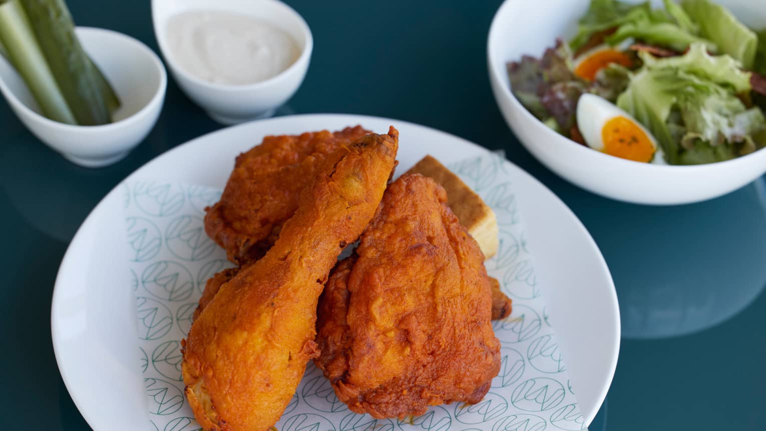 Plate of Marunouchi fried chicken, with side salad, ranch dressing and pickles in the background