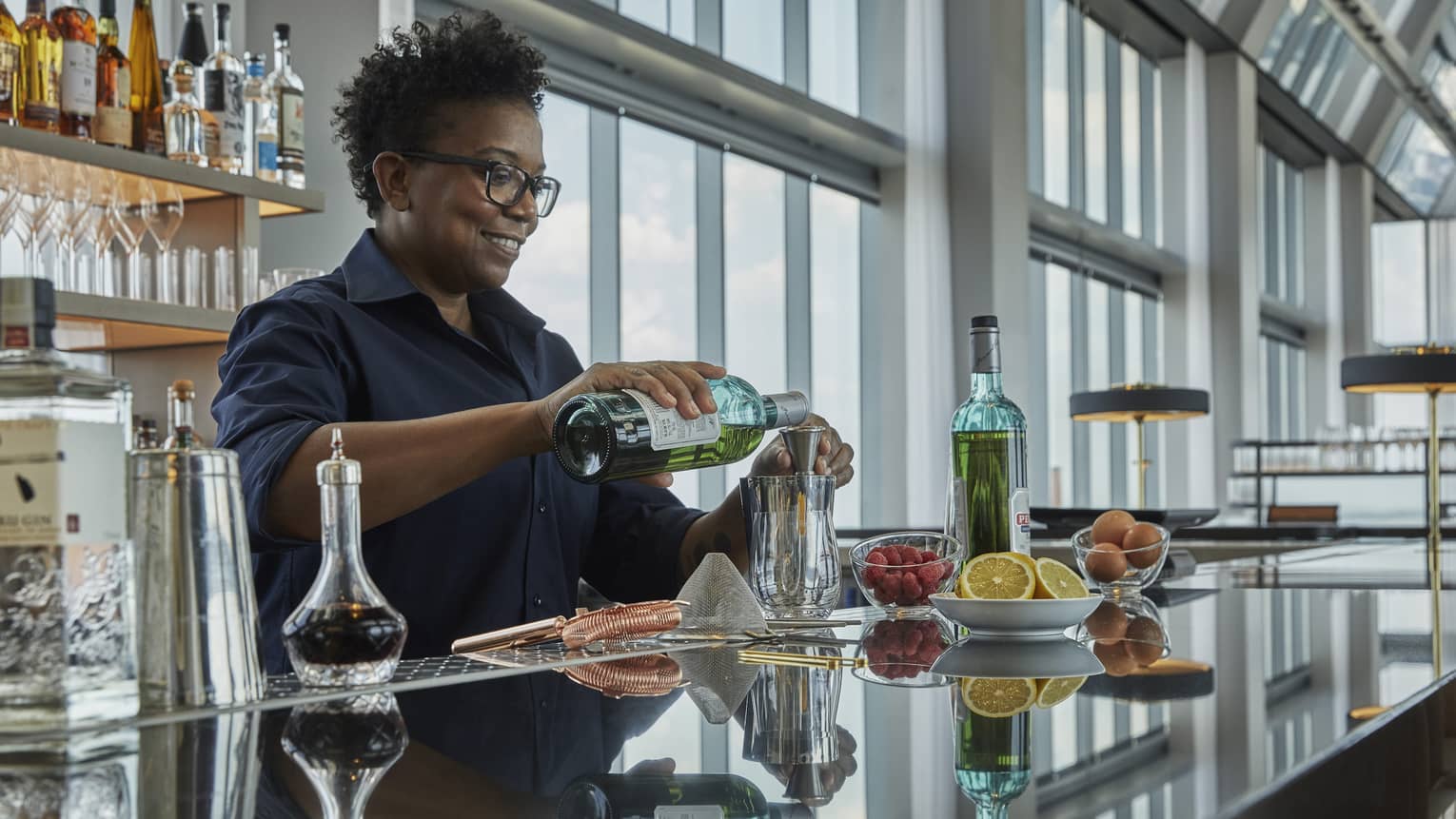 A four seasons bar tender pours a drink at the bar