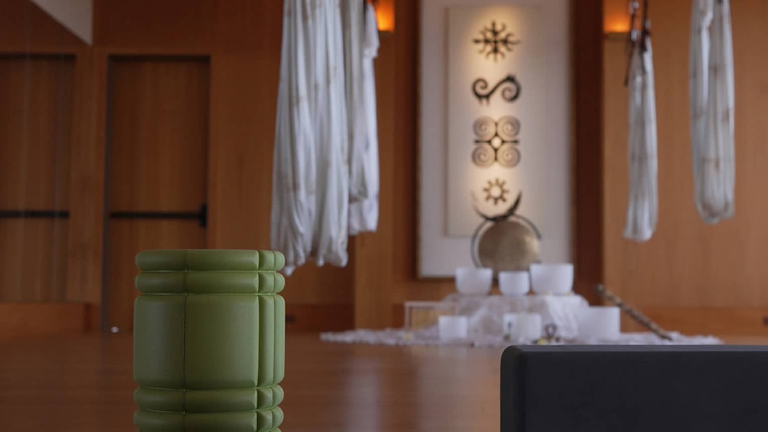 Fitness studio with hanging aerial yoga hammocks weights and a foam roller