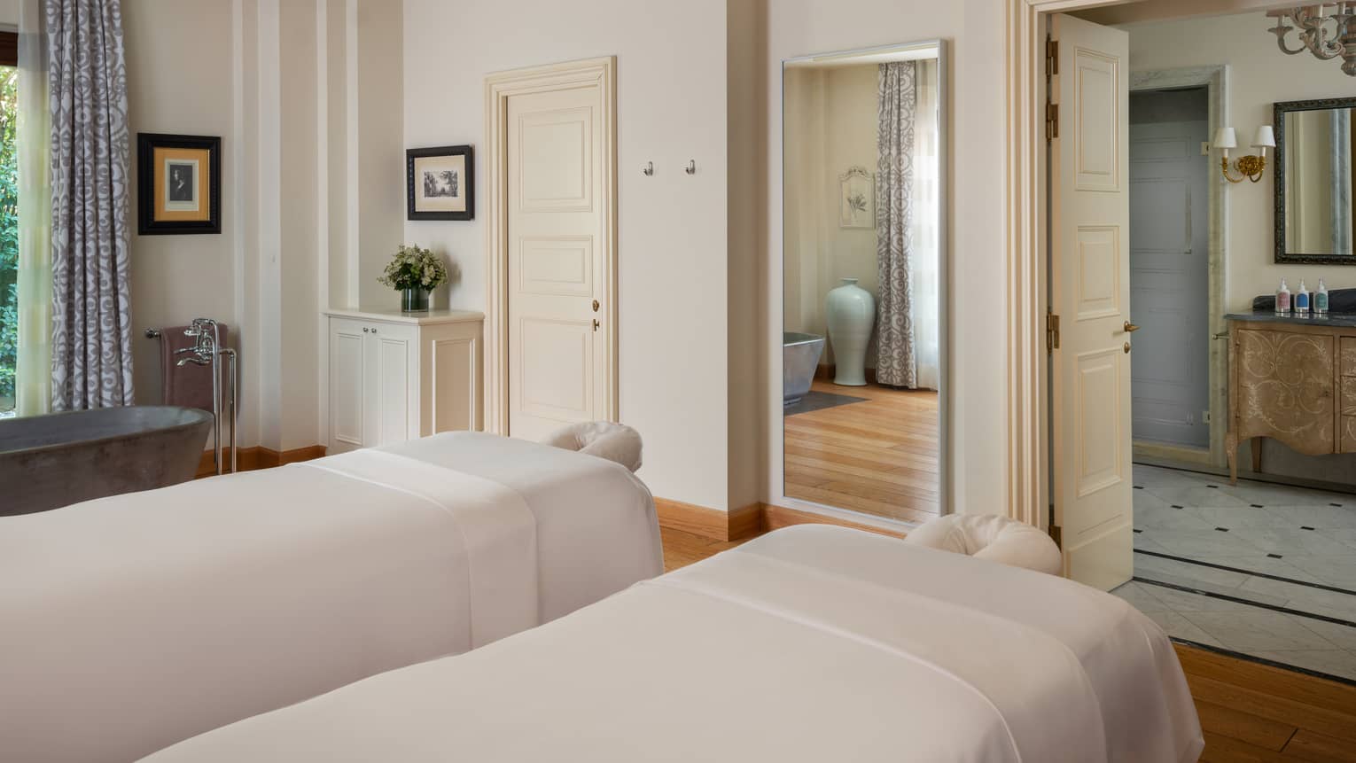 A light and spacious spa treatment room with two treatment tables side by side