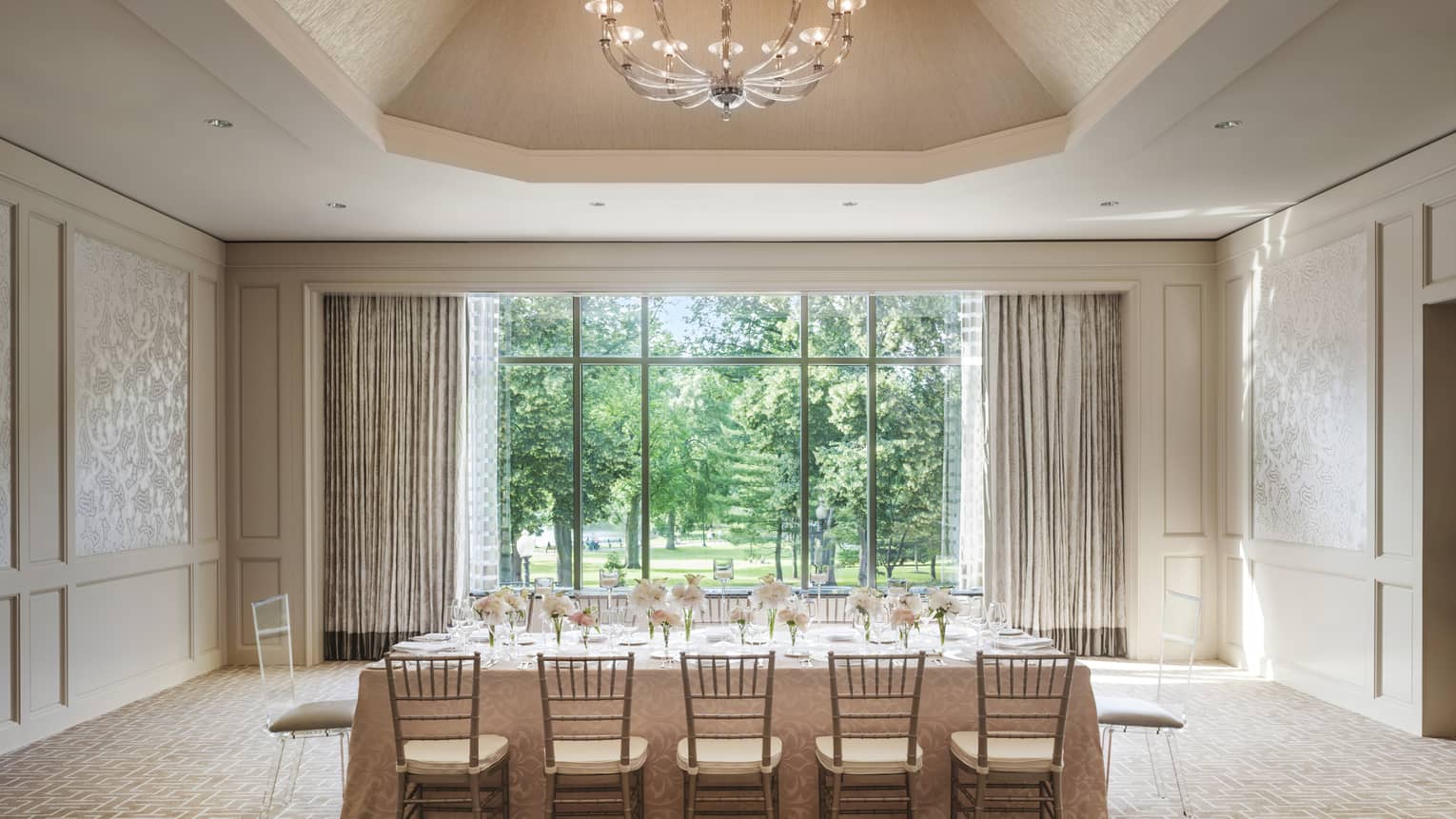 Private dining table with flowers under dome ceiling with crystal chandelier, by sunny window