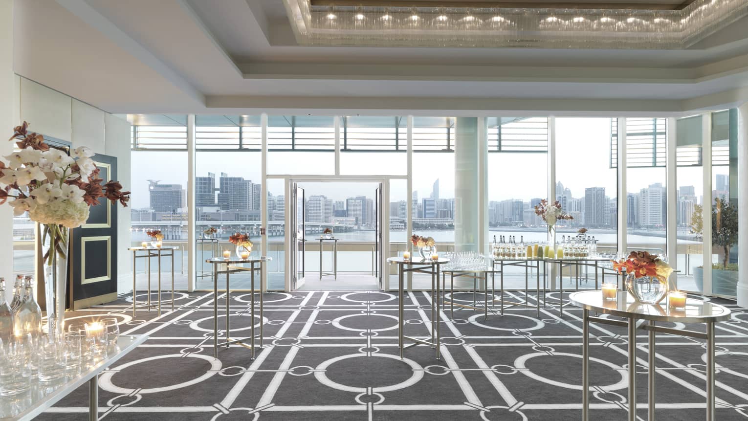 Cocktail reception tables with small candles, flowers in Liwa Ballroom, floor-to-ceiling windows 