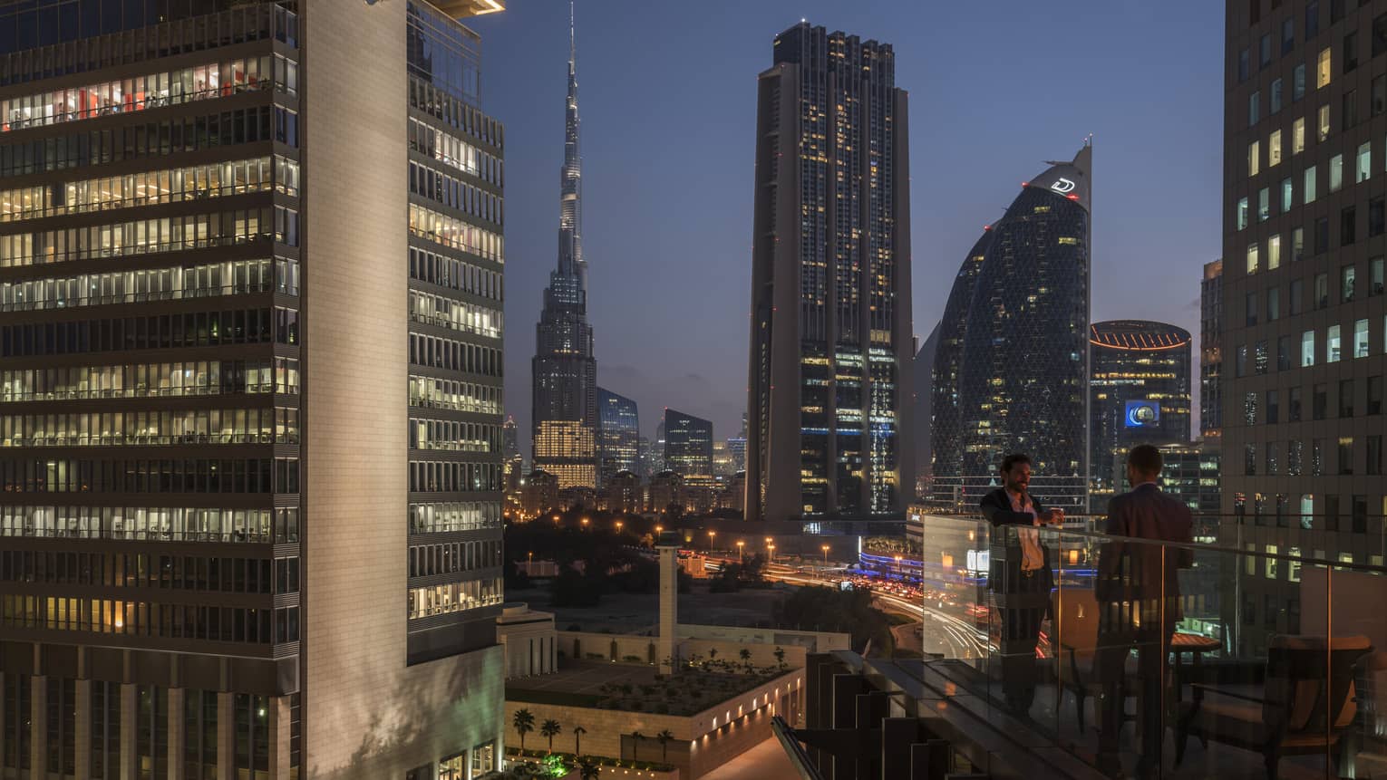Dubai business district skyline, city lights view from hotel terrace at night