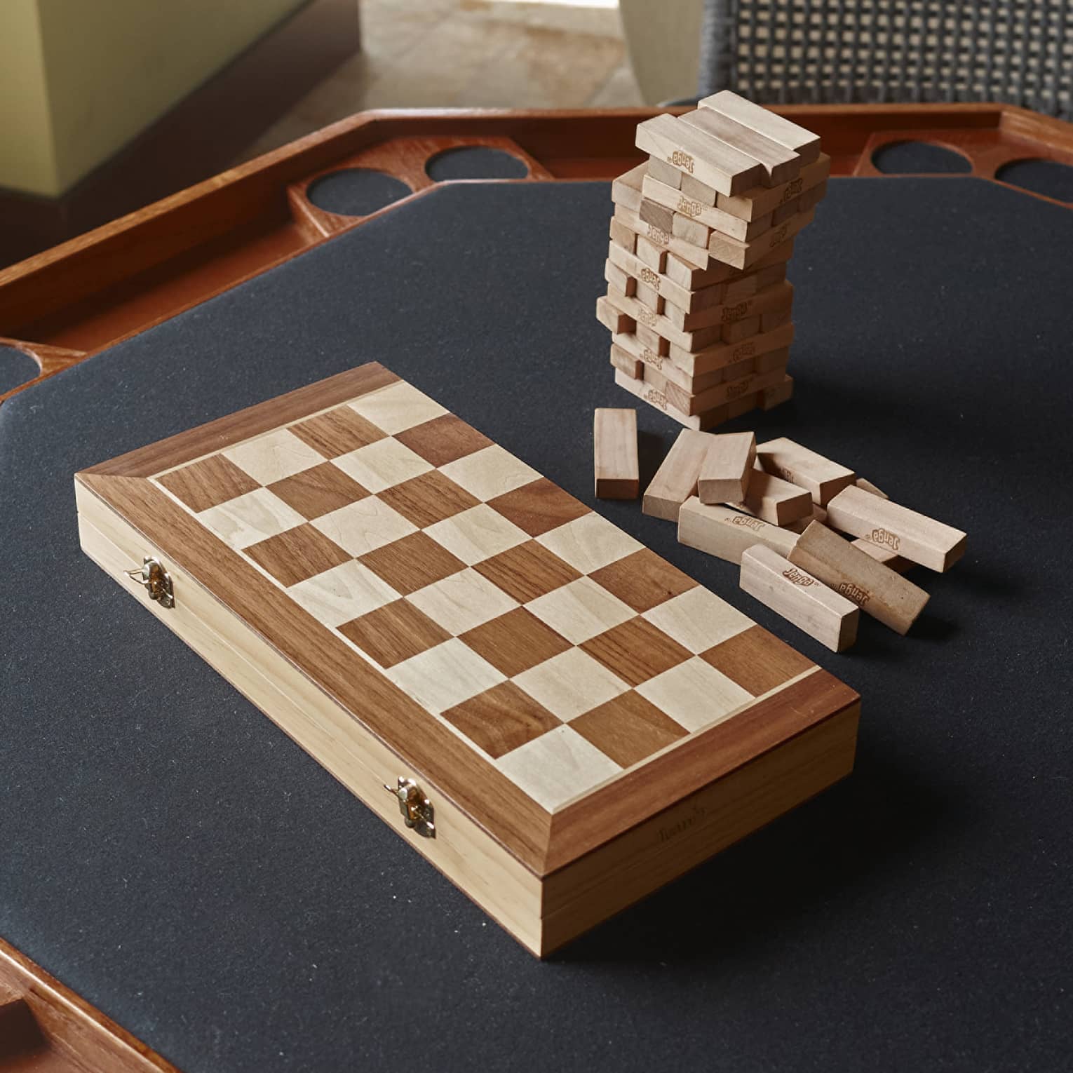 Jenga and a foldable wooden chess board sit on a black card table