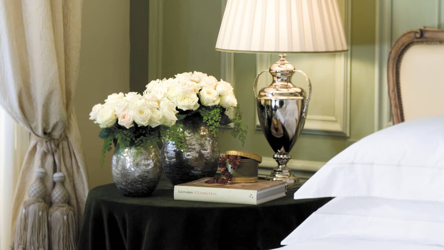 Superior Room silver lamp, vases with white roses, book on nightstand