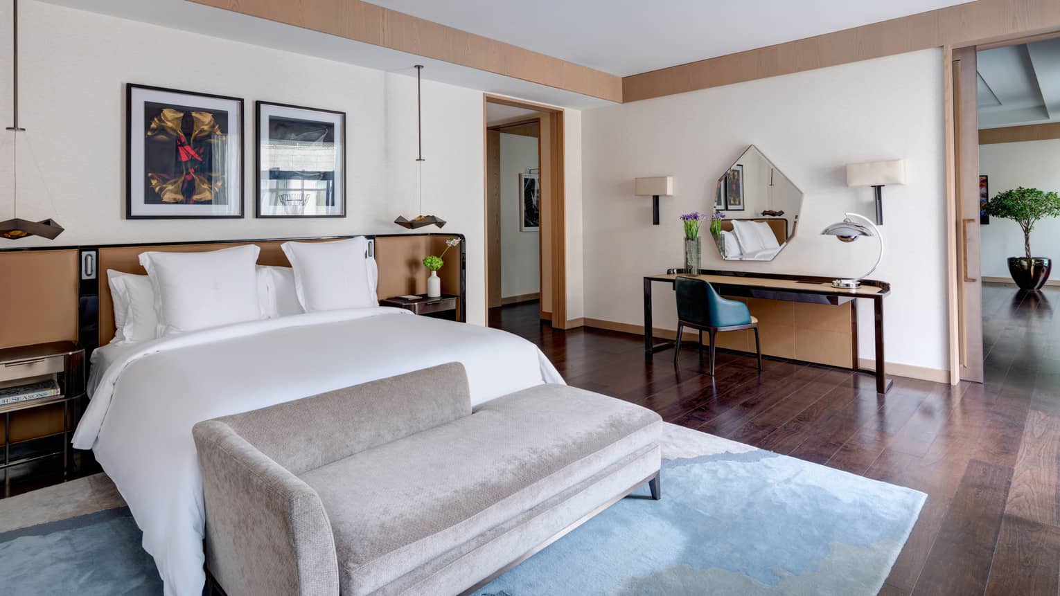 Bedroom with king bed, grey chaise and desk