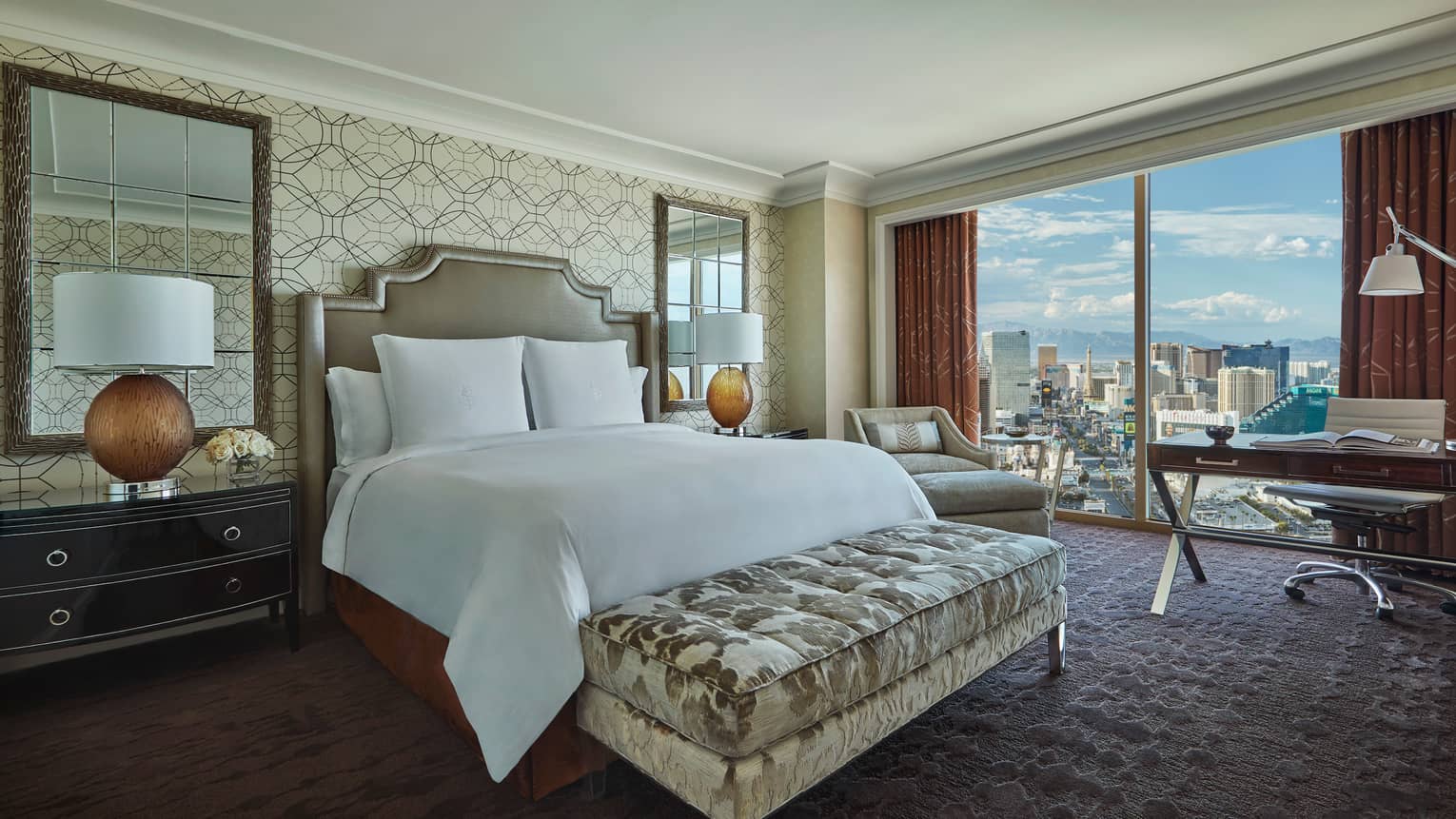 Strip-View room bed with plush velvet bench, mirrors, lamps by bed, desk by window