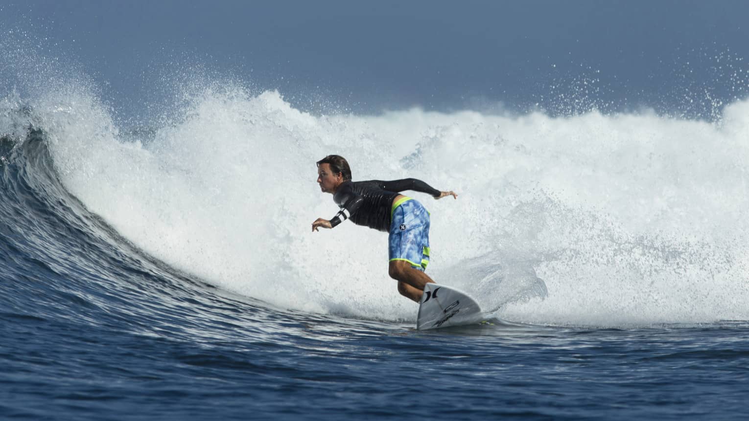 A guest surfs on the water in Bali with TropicSurf