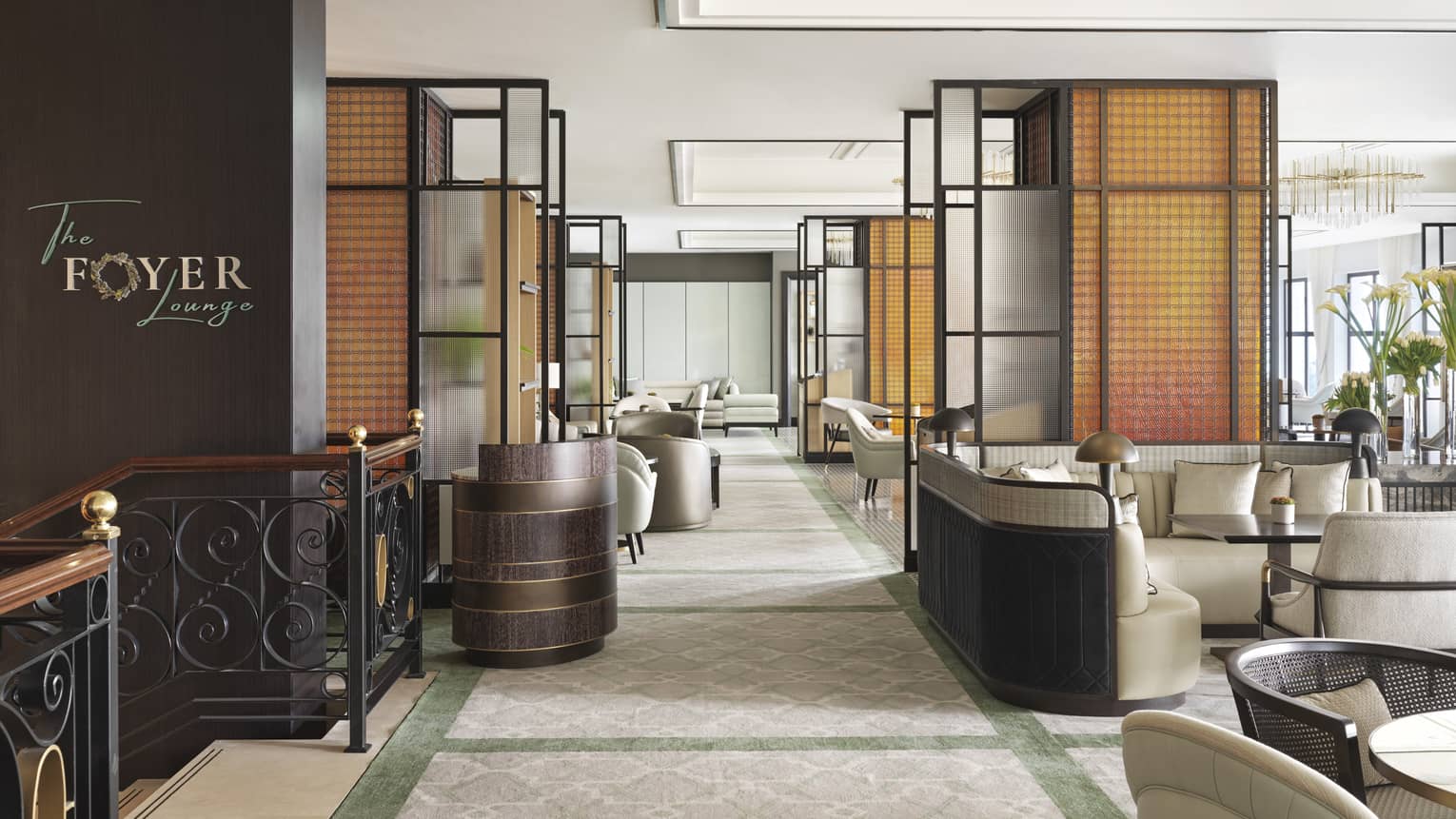 A view of the entrance to the Foyer Lounge complete with a black staircase, and several tables. 