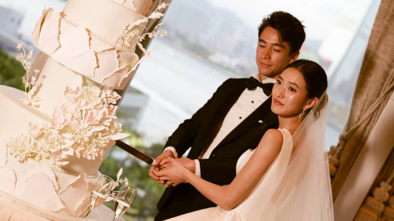 Bride and groom cut large wedding cake