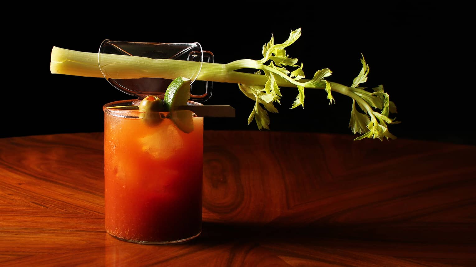 A red drink with a celery stick.