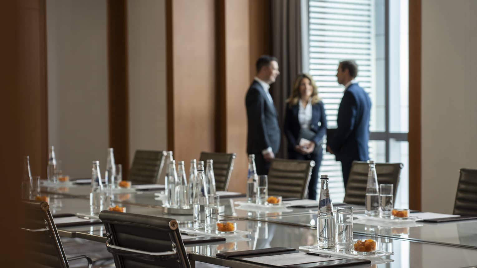 Three business people stand by window in Bal Harbour meeting room