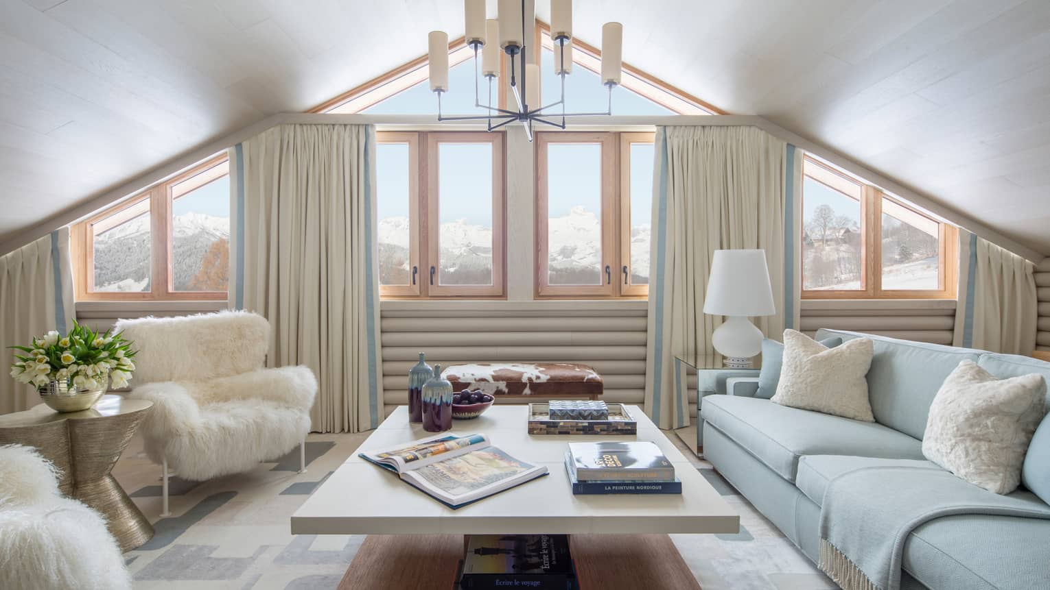 Suite Mont D'Arbois chandelier, windows under gable roof, white sofa, faux fur armchairs