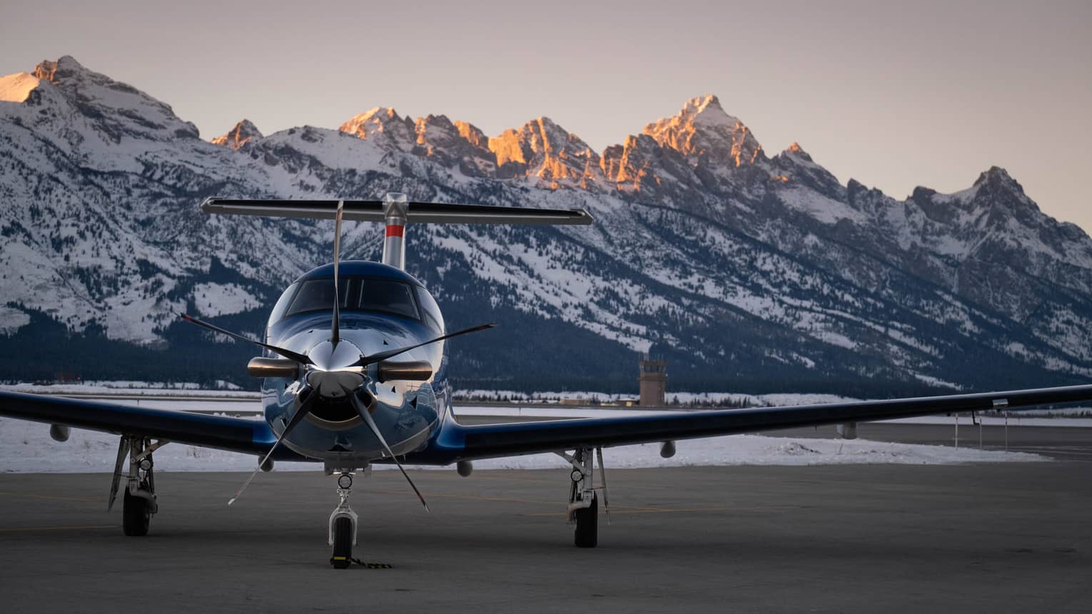 Airplane getting ready to take off with mountains in the background.