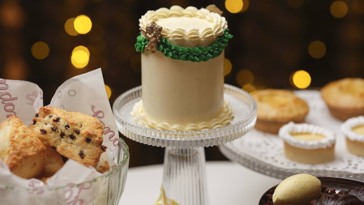 A cake stand and serving dishes bearing cakes and other baked goods