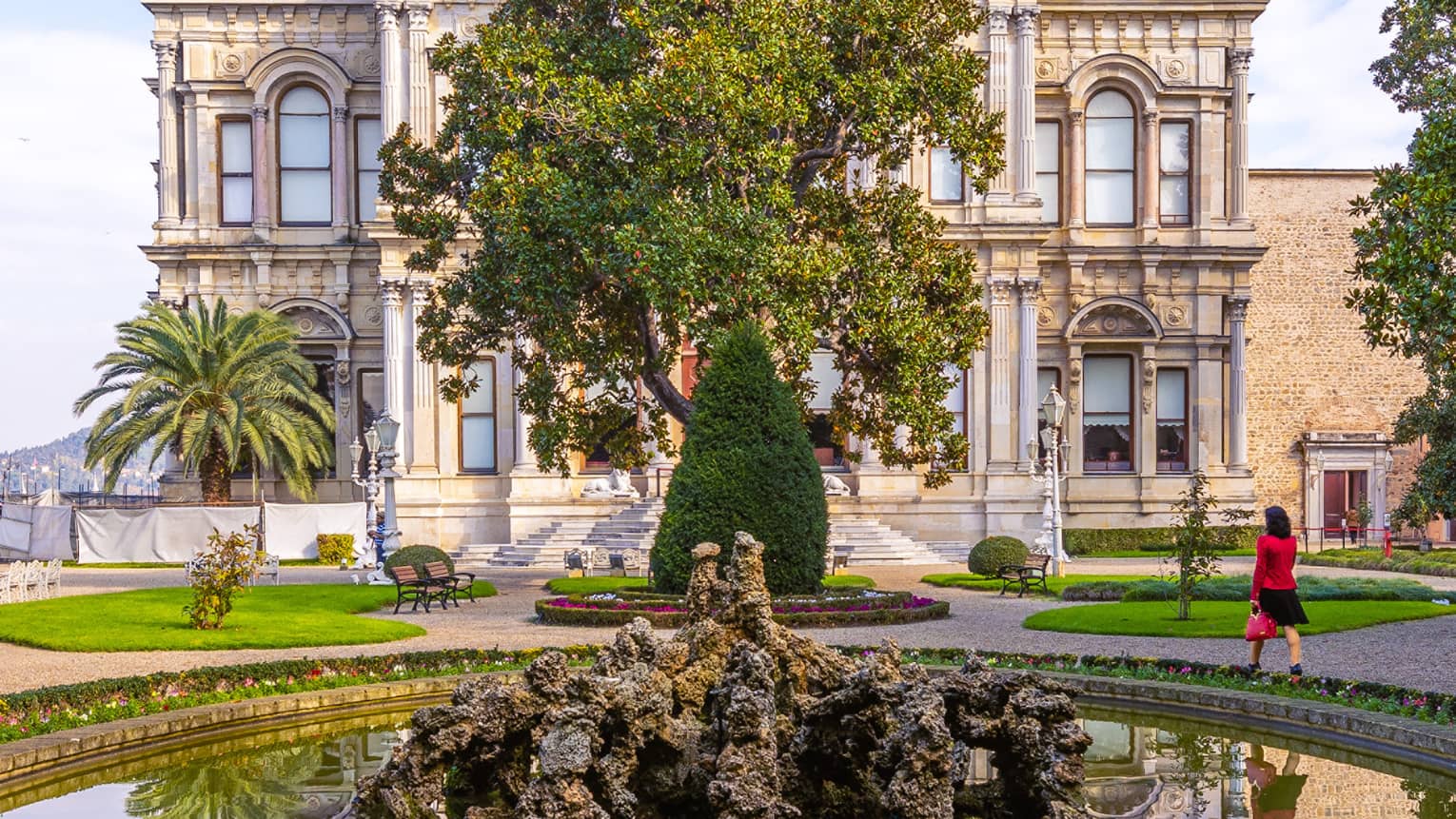 Small pond, fountain and tree in front of historic building