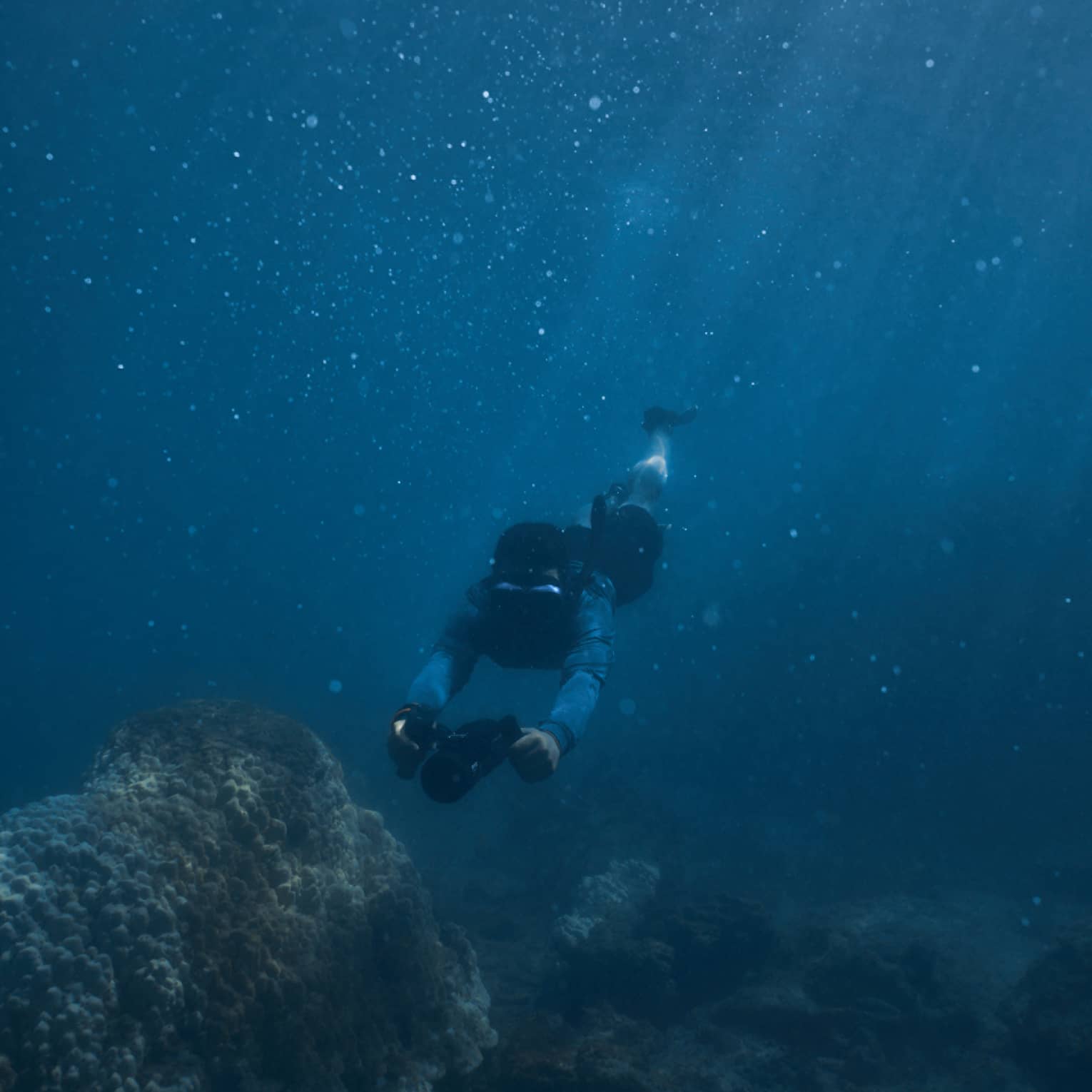 Person diving beneath the water using dive scooter