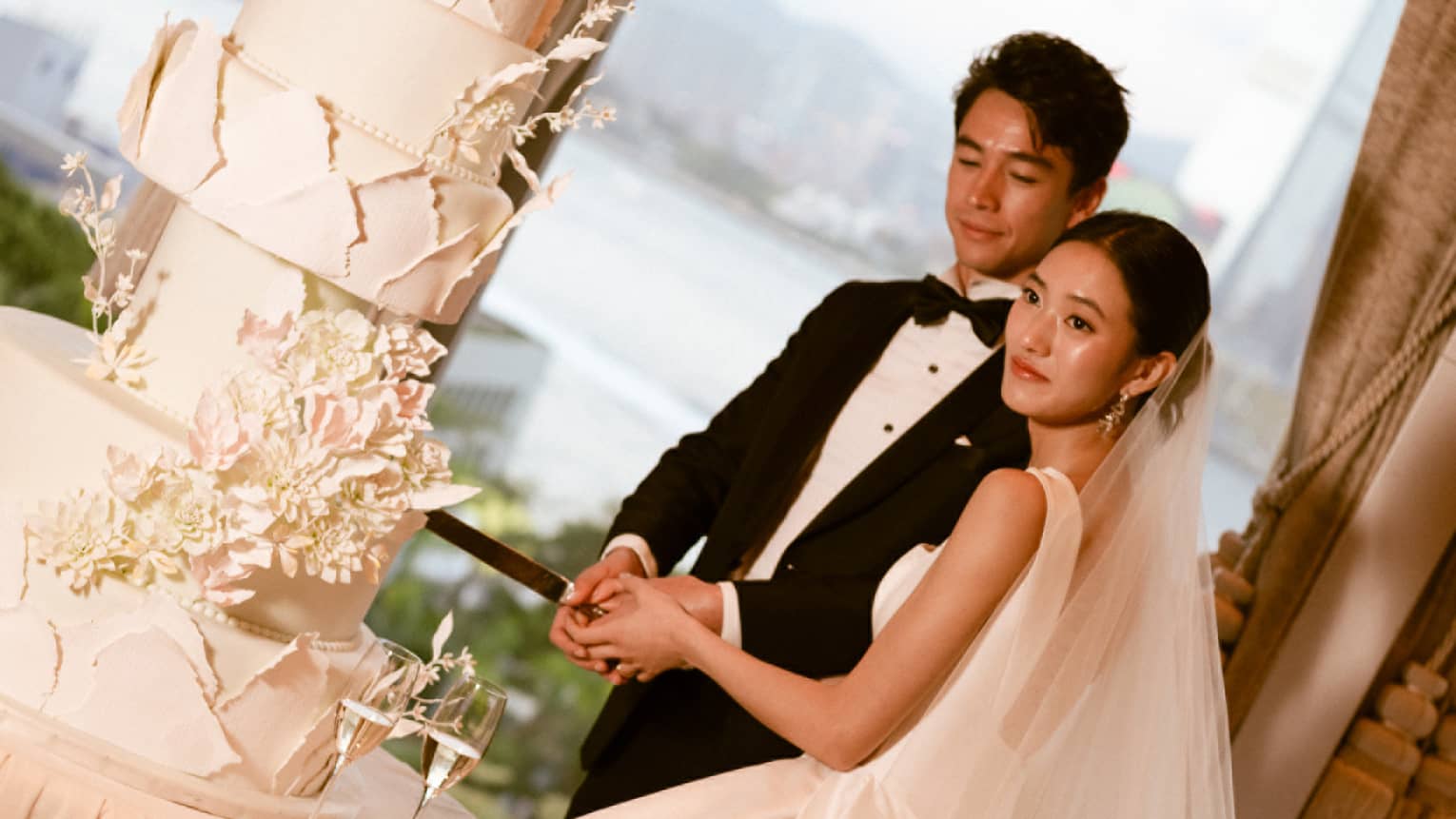 Bride and groom cut large wedding cake