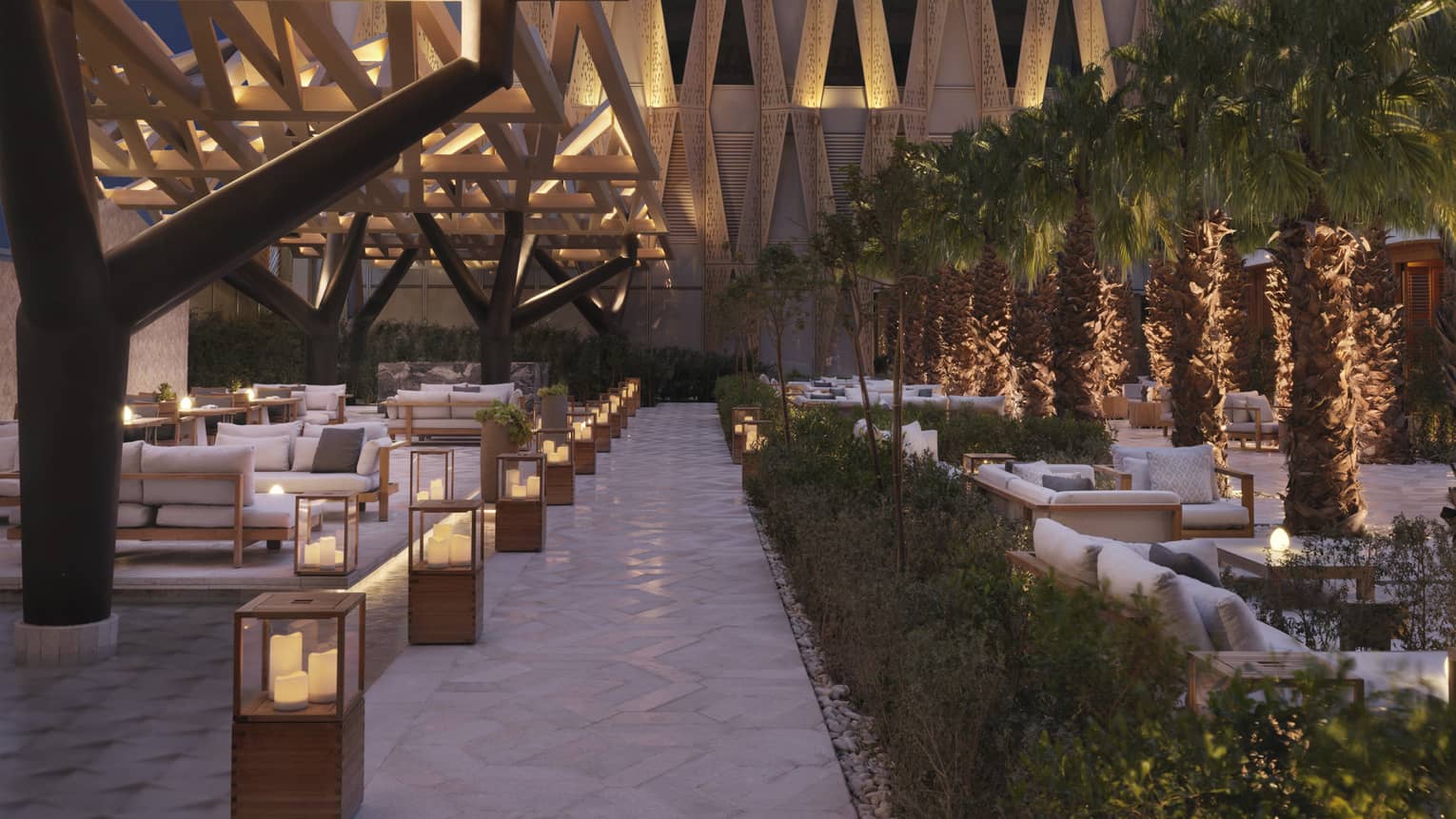 Illuminated outdoor patio sitting area with architectural designs on surround building.