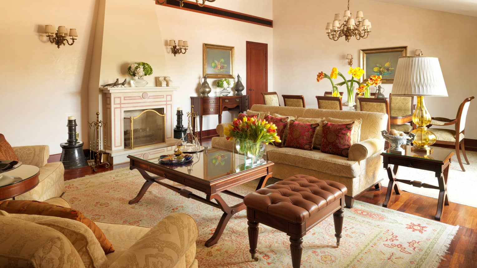 Large suite living room with sofas, fireplace mantle, dining table, Ottoman-inspired decor