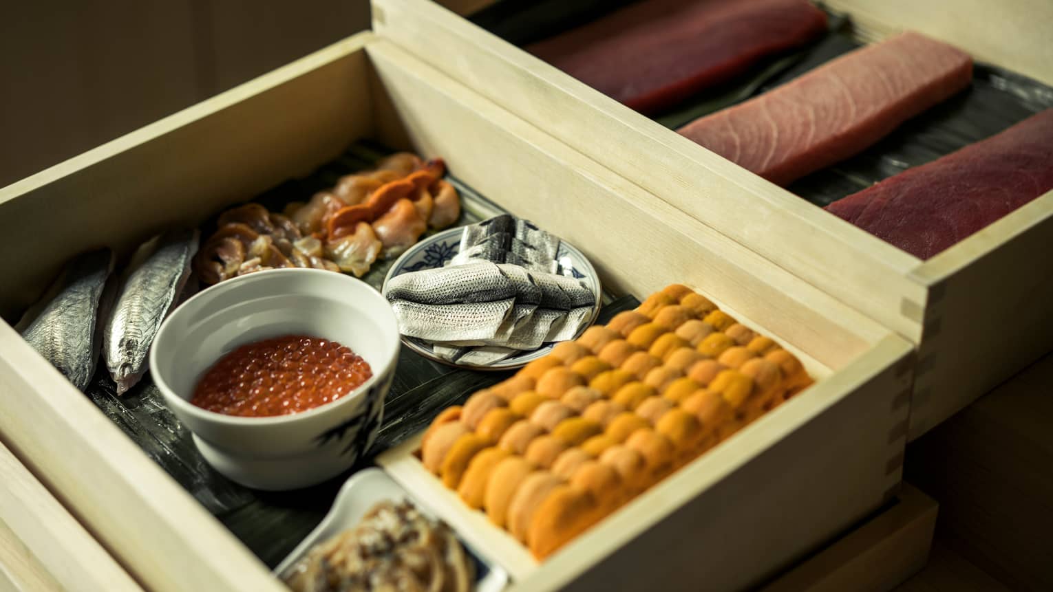 Close-up of bamboo trays with raw fish, roe