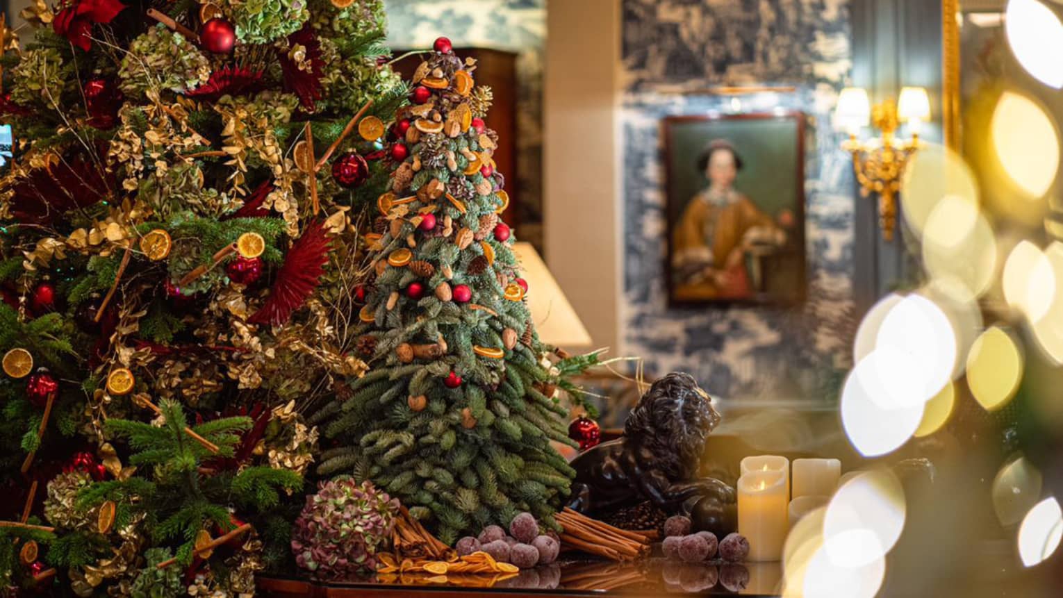 Tabletop with colourful Christmas tree and fully decorated tree in backdrop