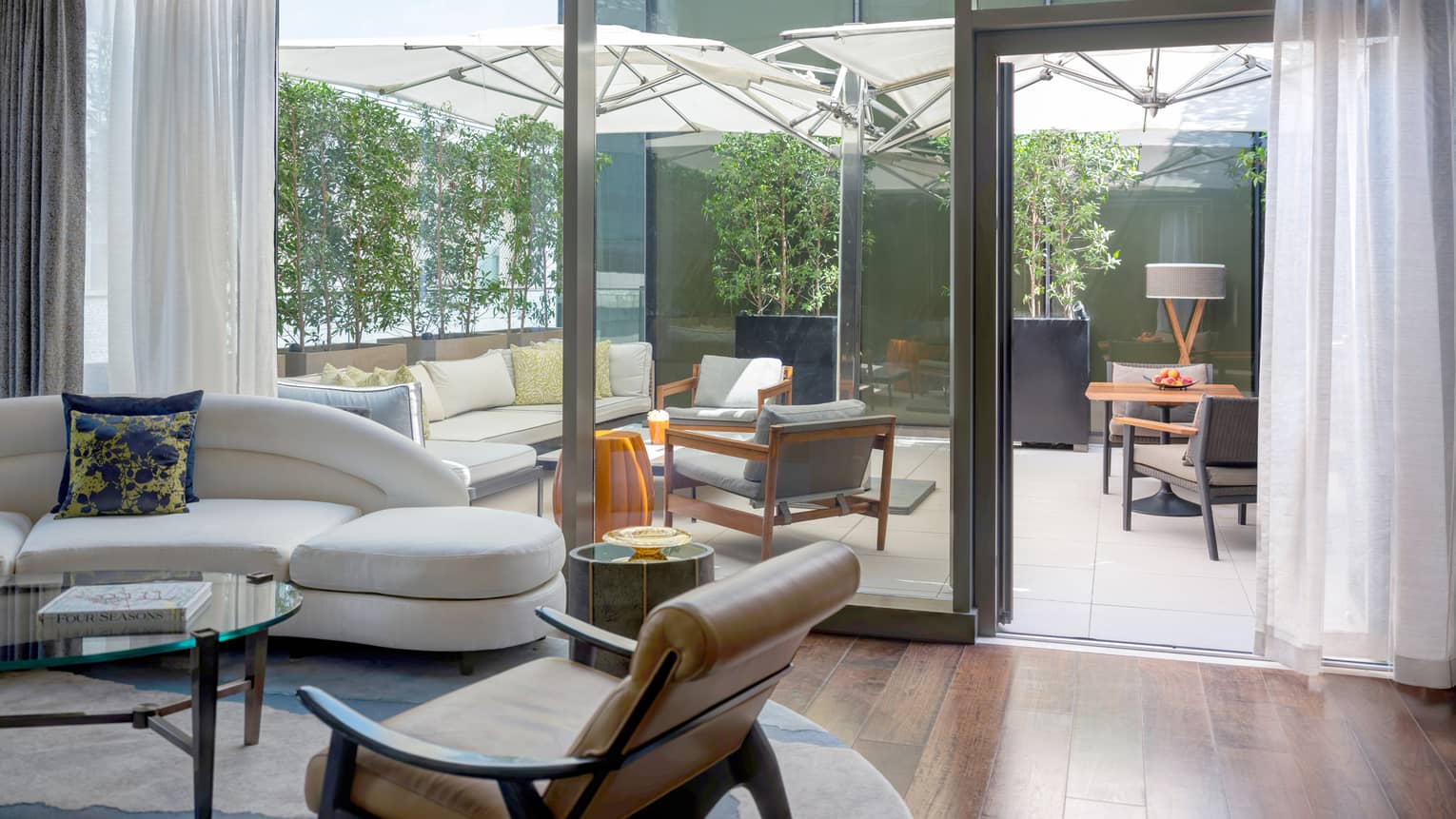 Living room with wooden floors, walk-out terrace with lounge furniture