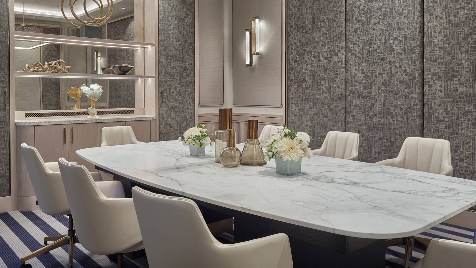 Turay room with marbled conference table, seven white leather chairs, mirrored armoire