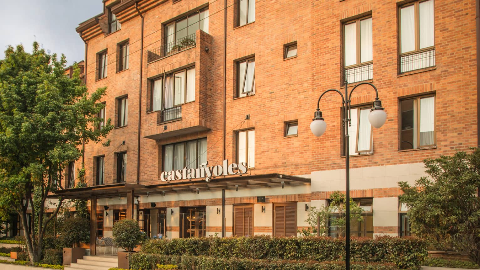 The outside facade of the hotel, made of a brown stone.
