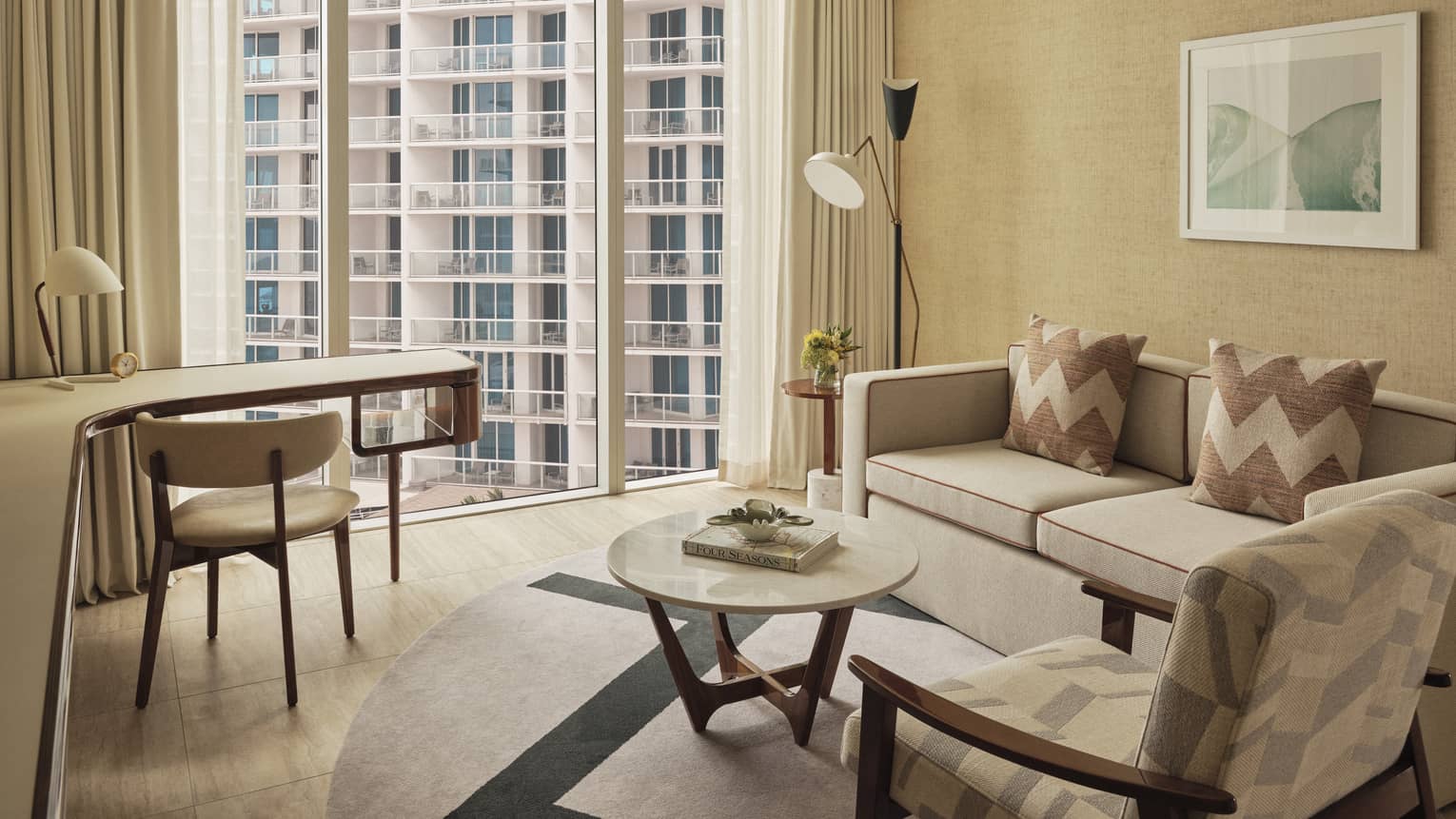 Living area with wall of windows looking out to high-rise building