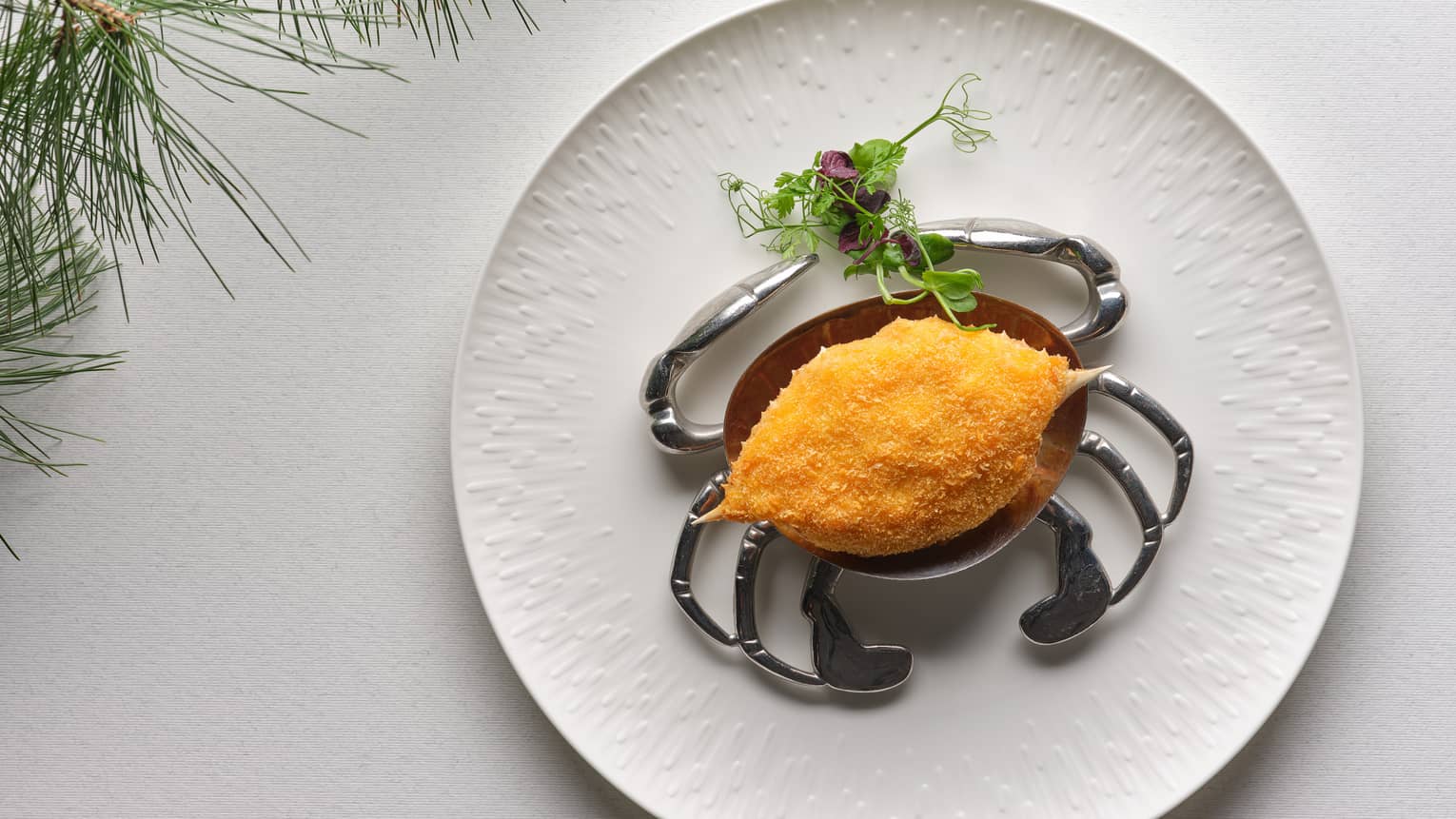 Deep-fried Crab Shell on round white plate with microgreen garnish