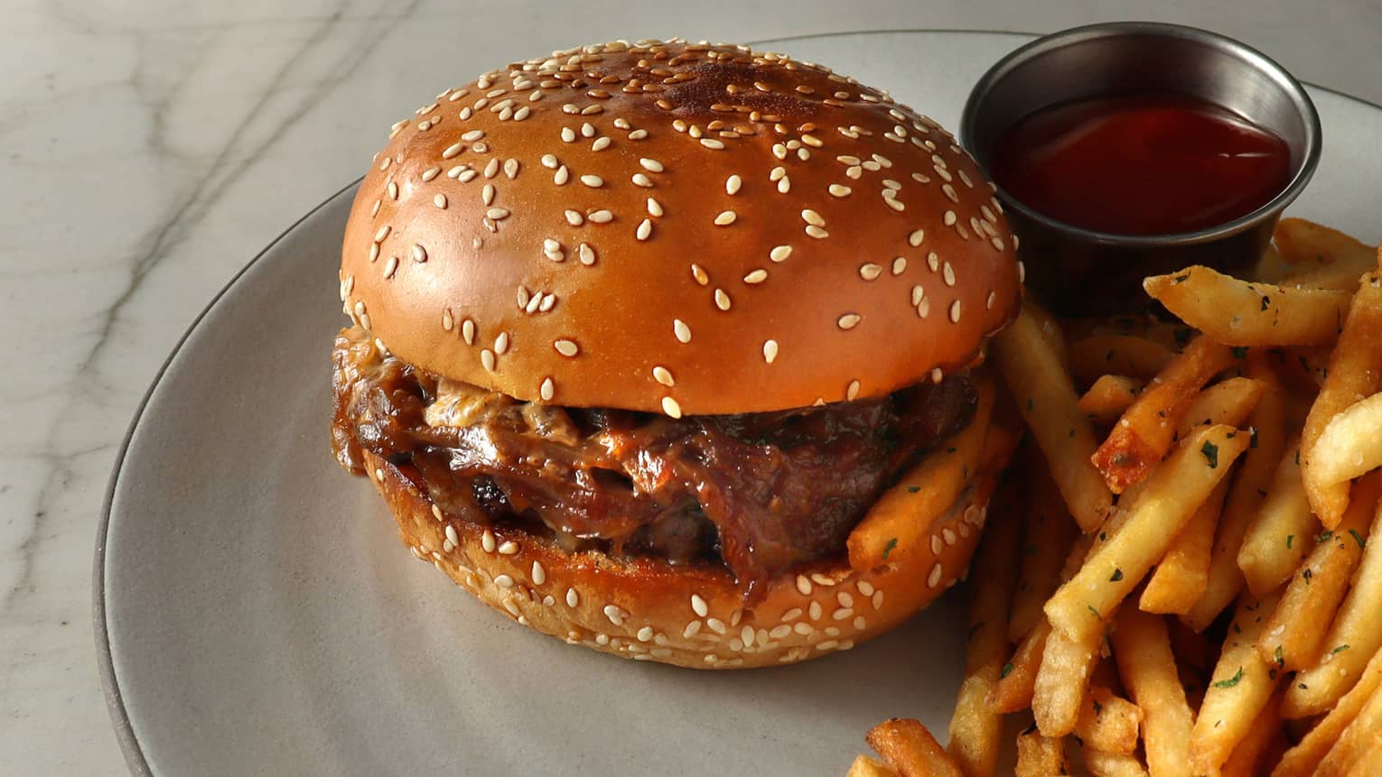 A burger and fries with ketchup.