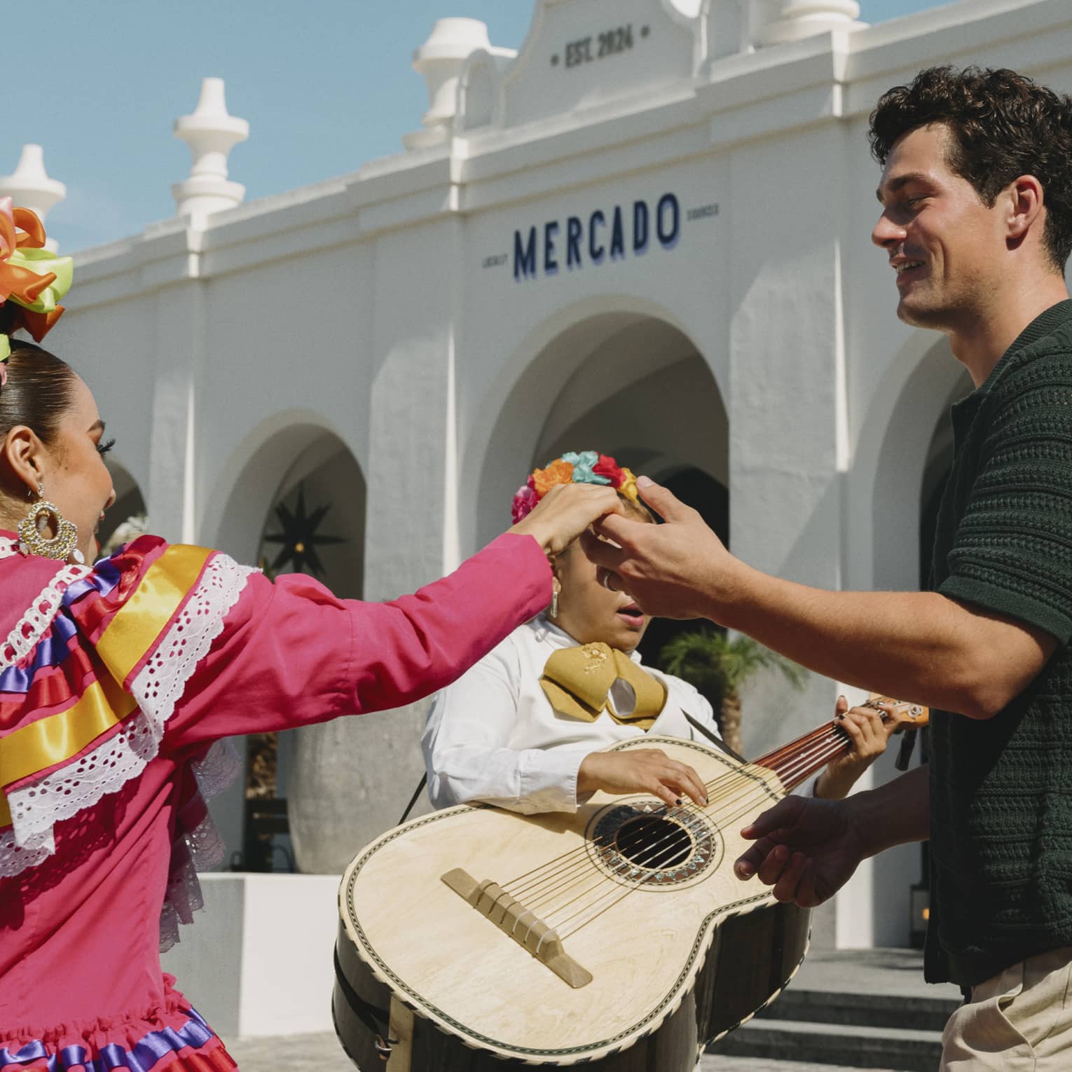 Man and woman dance in front of mariachi band