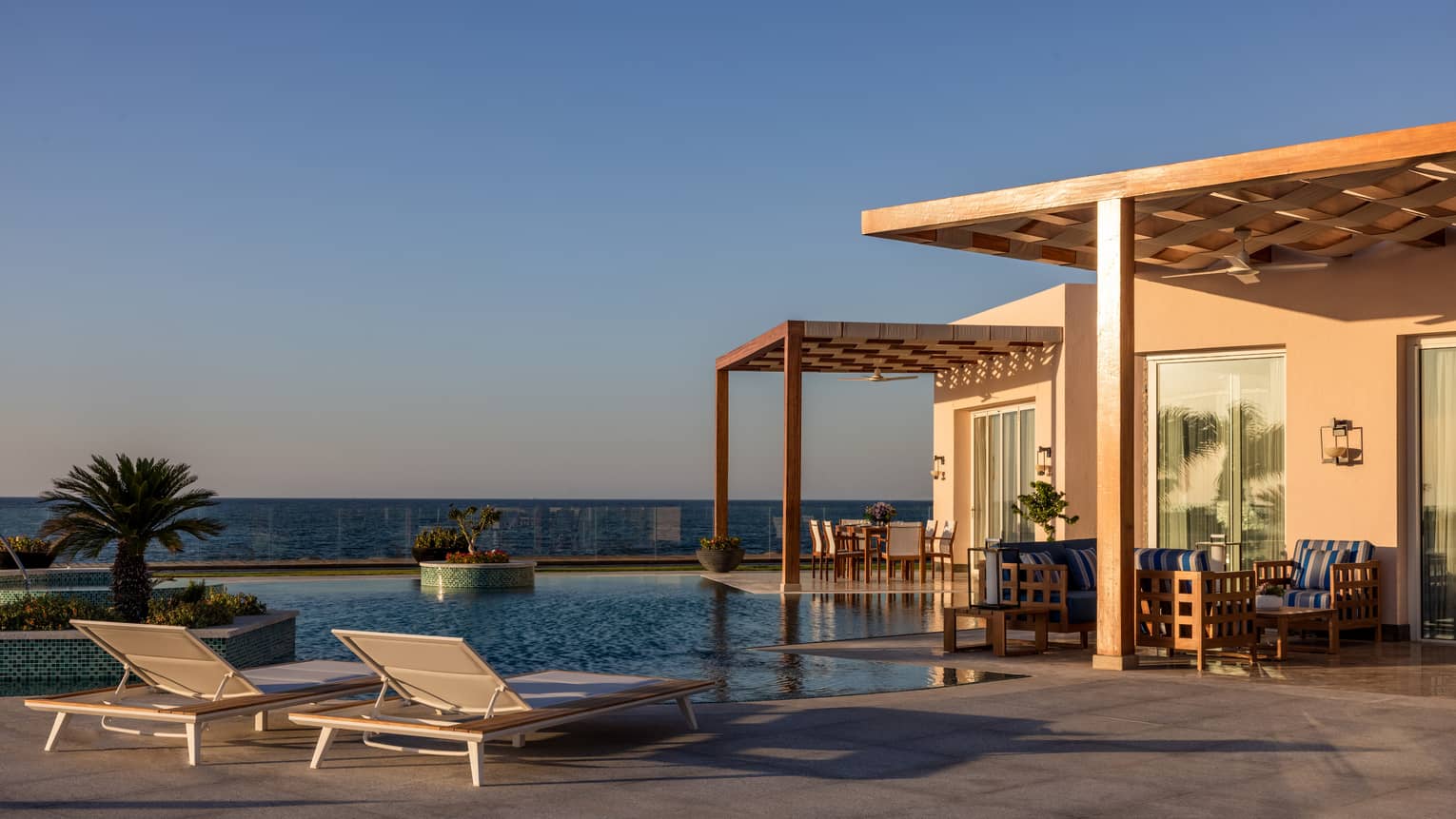 Pool and lounge chairs on patio of The Palace at dusk