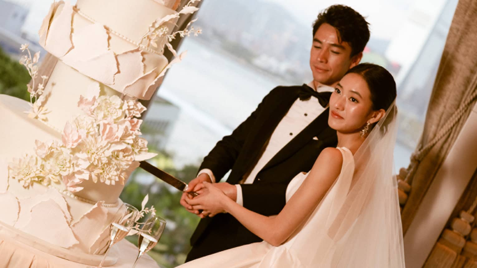 Bride and groom cut large wedding cake