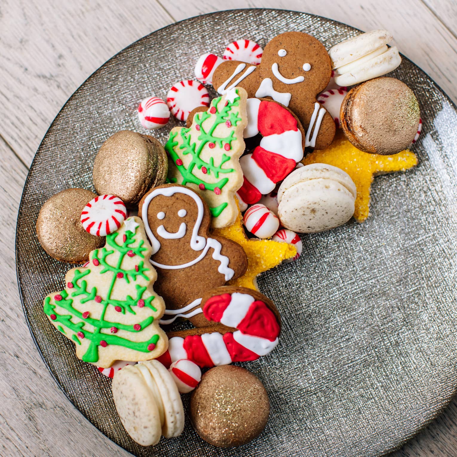 A plate of holiday sugar cookies – christmas trees and ginger bread men and candy canes