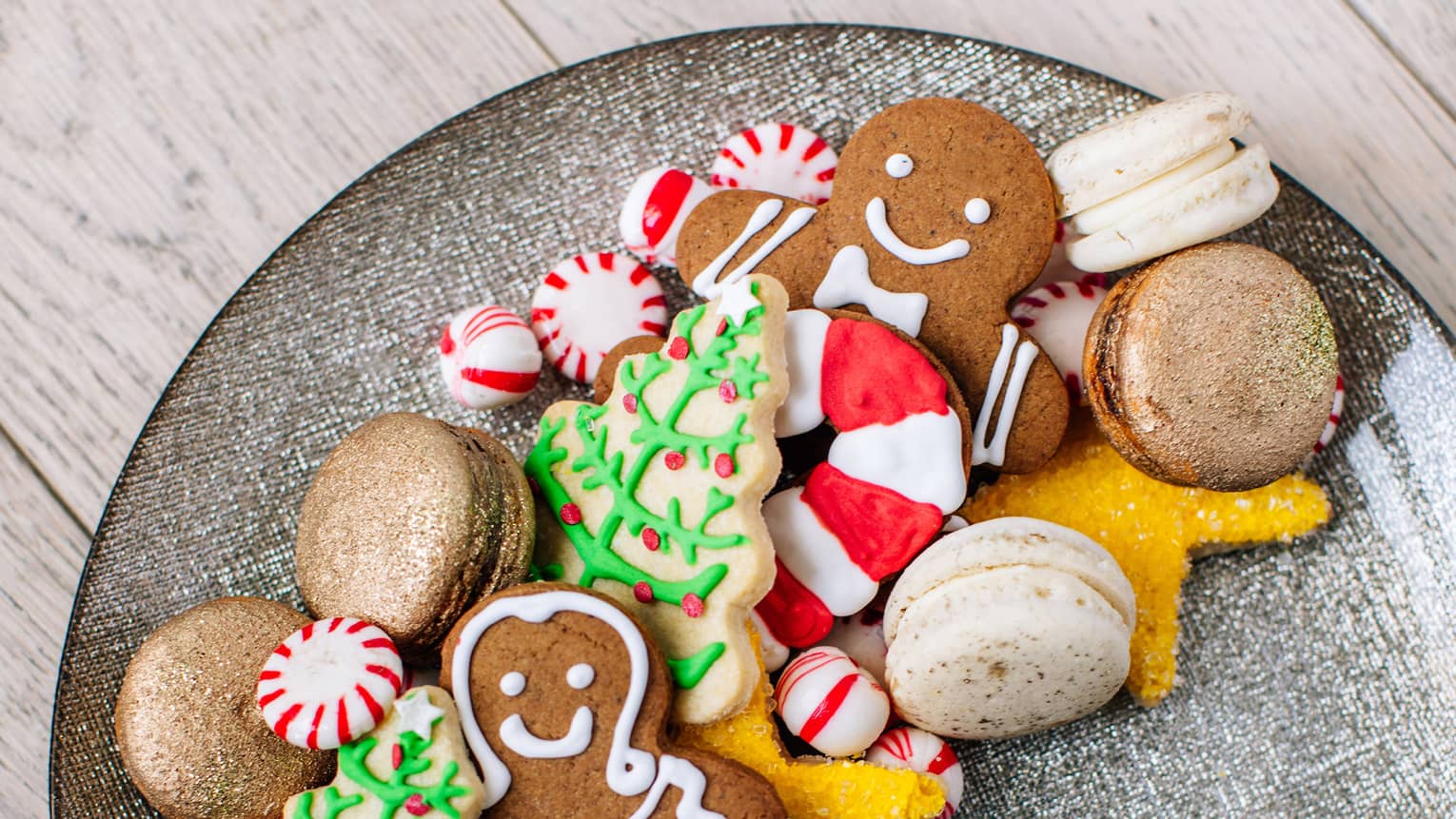 A plate of holiday sugar cookies – christmas trees and ginger bread men and candy canes