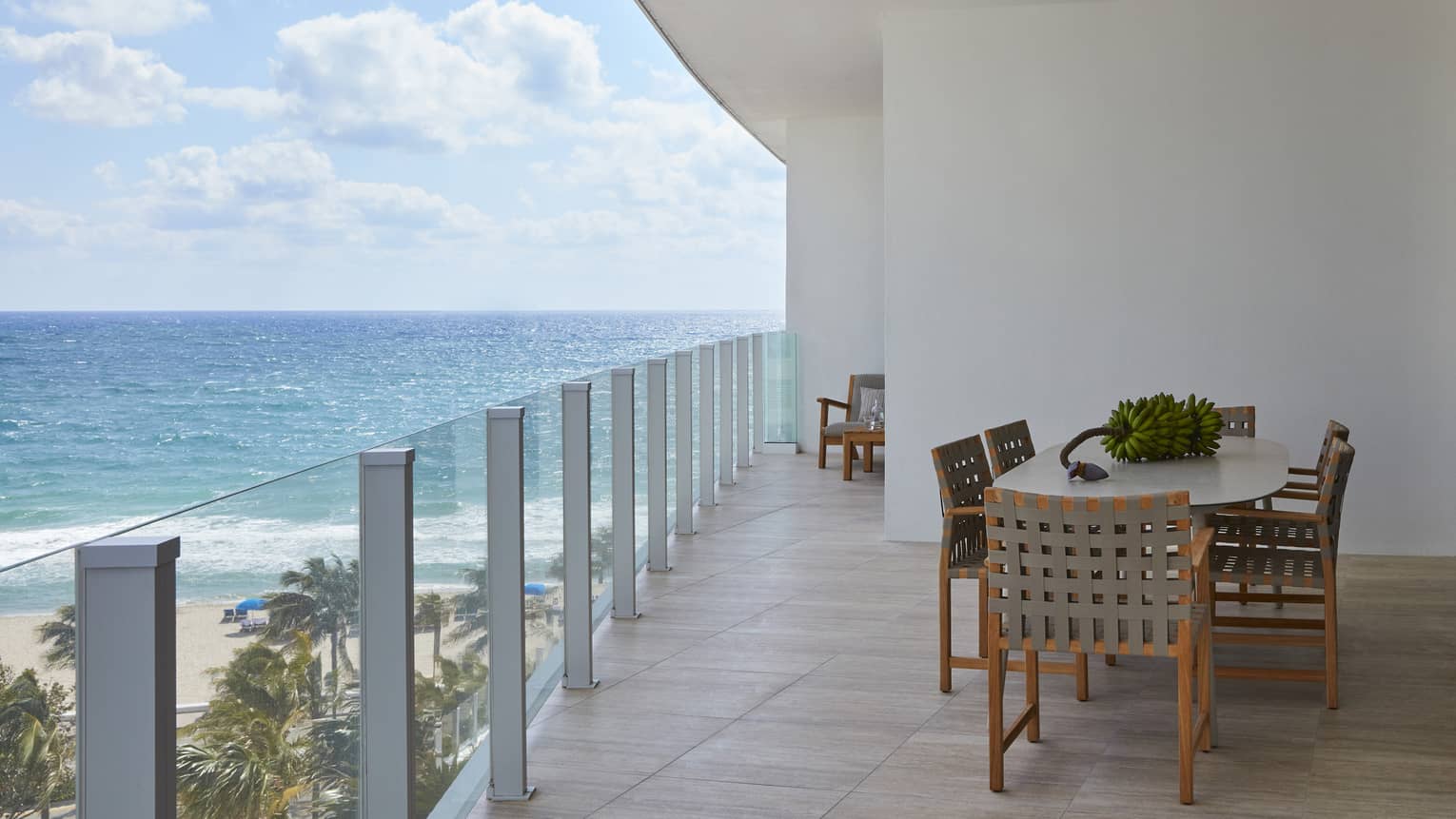 Glass railing terrace with dining table and ocean view