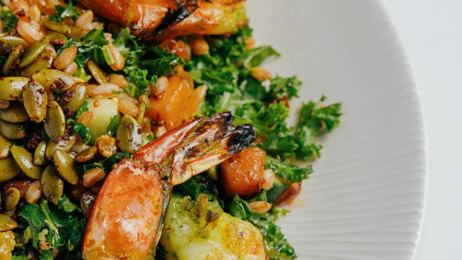 Salad with roasted shrimp, squash, kale, ancient grains, pepitas and golden raisins